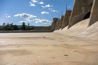 concrete walls with a sky background on the ground of an empty lot, with dirt and cement around