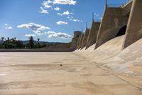 concrete walls with a sky background on the ground of an empty lot, with dirt and cement around