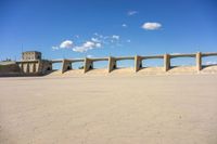 three concrete bridge on the ground with a building in the background, under a blue sky