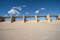 the concrete structure is all over with some clouds in the sky behind it and below it