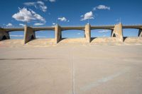 the concrete structure is all over with some clouds in the sky behind it and below it