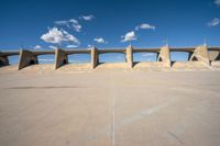 the concrete structure is all over with some clouds in the sky behind it and below it