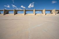 the concrete structure is all over with some clouds in the sky behind it and below it