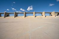 the concrete structure is all over with some clouds in the sky behind it and below it