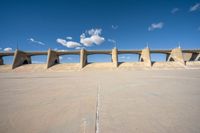 the concrete structure is all over with some clouds in the sky behind it and below it