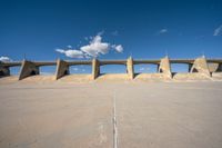 the concrete structure is all over with some clouds in the sky behind it and below it