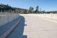 this is an empty bridge with concrete and cement ledges that look like it has been set on land