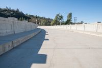 this is an empty bridge with concrete and cement ledges that look like it has been set on land