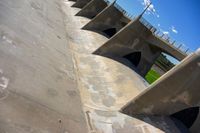 a view of the underside of an old concrete bridge from below, in which are four curved pillars