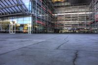 a building that is very large and empty with concrete floors, some windows and glass