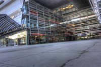 a building that is very large and empty with concrete floors, some windows and glass