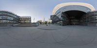 this is a fisheye photo taken outside the building shows stairs and a circular shaped facade