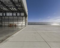 view of an empty hangar with an entrance open to the area with vehicles parked inside