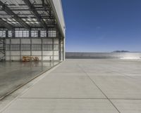 view of an empty hangar with an entrance open to the area with vehicles parked inside