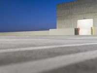 a small building with no doors is on the concrete flooring and some lines painted out