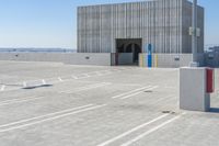 the side entrance of a building with painted columns and parking spaces to the left and right