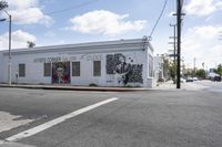 a white painted building with graffiti written on it that reads the former james riley studio