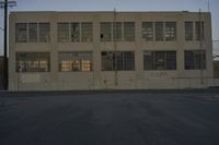 a white building with windows with graffiti on the sides of it is standing on the side of a road