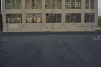 a white building with windows with graffiti on the sides of it is standing on the side of a road