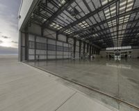 an empty building with a large glass partition in the middle of it is a very big concrete floor