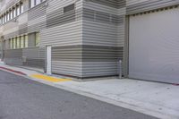 two garage doors are located next to a parking meter at the sidewalk by the building