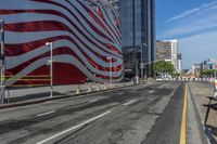 a person is riding a bike on a city street in front of an american flag