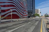 a person is riding a bike on a city street in front of an american flag