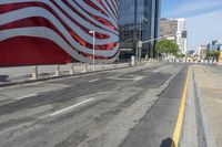 a person is riding a bike on a city street in front of an american flag