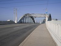 a large bridge over a road under a blue sky and wispy clouds in the distance