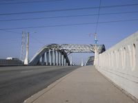 a large bridge over a road under a blue sky and wispy clouds in the distance