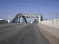 a large bridge over a road under a blue sky and wispy clouds in the distance