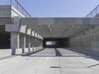 empty freeway going through an overpass under the bridge area of a highway with several ramps