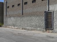 a fire hydrant near the side of a building with some bars attached to it