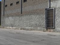 a fire hydrant near the side of a building with some bars attached to it