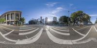 view from the bottom of this fish eye lens of the street intersection with buildings and trees