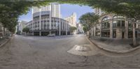 a fisheye lens on the street in front of tall buildings with trees and blue skies