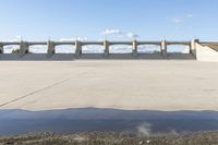 a man that is standing near a body of water with a skateboard in his hand