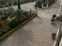 a long courtyard surrounded by lots of flowers and greenery area in the foreground