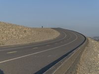 the road is curved and empty with no cars on it, as if for most vehicles