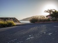 a lone motorcyclist passes along the beach line as the sun sets in the background