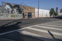 an empty road and a wall with graffiti on it in the city of los angeles, california