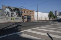 an empty road and a wall with graffiti on it in the city of los angeles, california