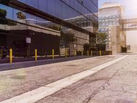 an empty street with a view on an office building from behind the walkway, along side of a glass building