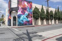 a building with colorful graffiti art and power lines on the side walk in hollywood beach