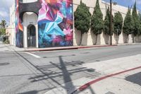 a building with colorful graffiti art and power lines on the side walk in hollywood beach