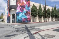 a building with colorful graffiti art and power lines on the side walk in hollywood beach