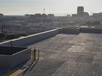 a building roof with a skateboard parked on it's flat deck near a fence