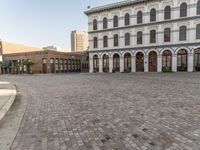 a large building has windows that open onto a courtyard with several smaller windows and doors