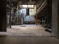 a building that has an industrial looking area with concrete flooring and exposed wall with old machinery