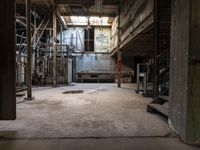 a building that has an industrial looking area with concrete flooring and exposed wall with old machinery